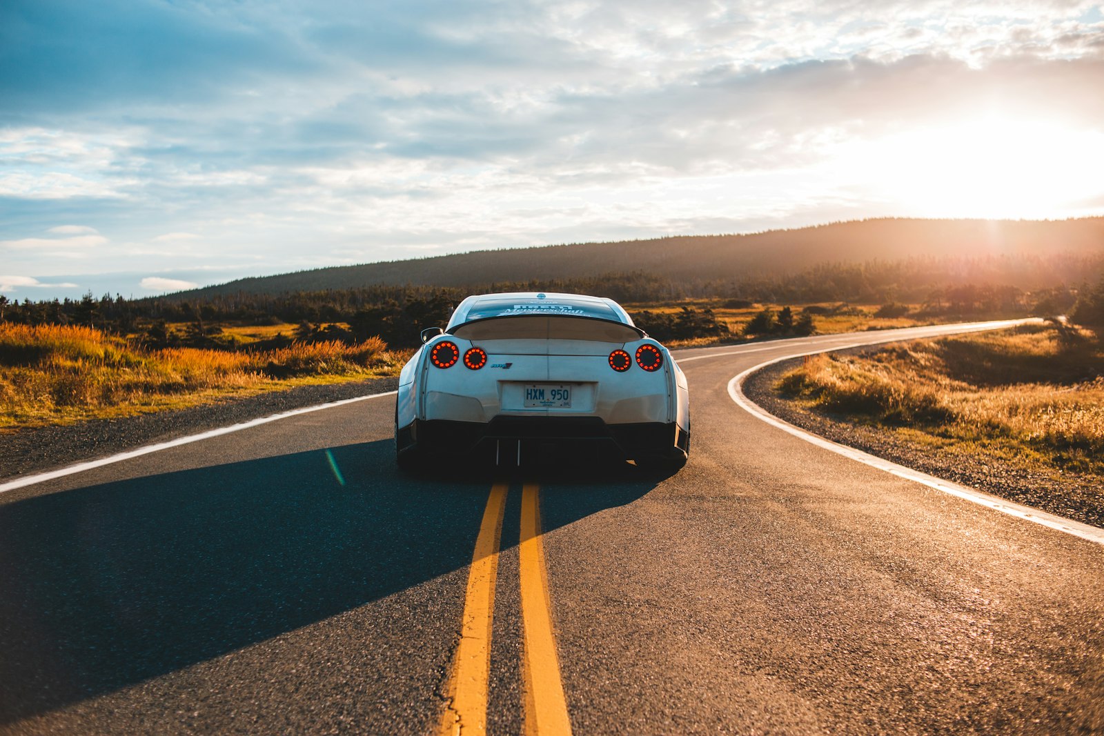 Sportowe auto na pustej drodze o zachodzie